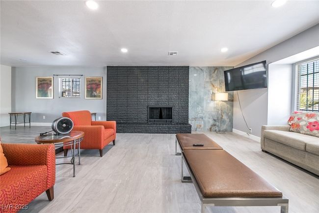 Living area with a brick fireplace, recessed lighting, light wood-style floors, and baseboards | Image 6