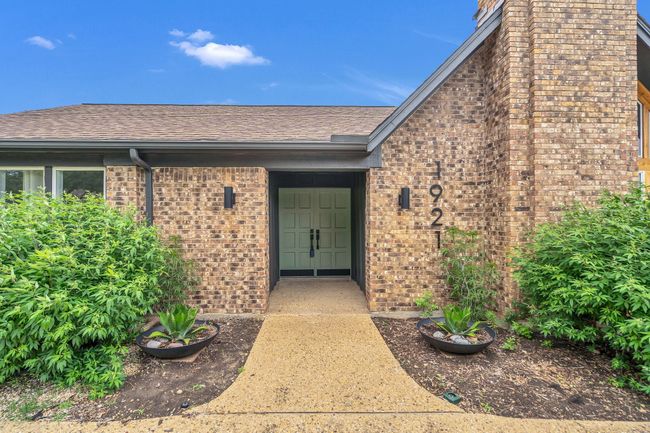 Entrance to property with brick siding, a chimney, and roof with shingles | Image 4