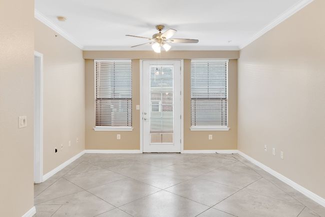 Living room featuring ornamental molding, light tile patterned flooring, a ceiling fan, and baseboards. All new paint and blinds. | Image 9
