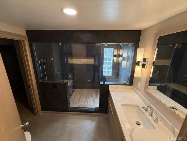Bathroom featuring vanity, a stall shower, light tile patterned floors, and recessed lighting | Image 21