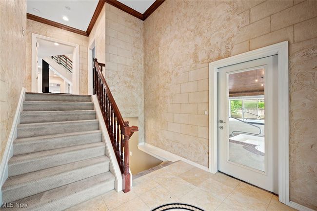 Entryway to the pool featuring ornamental molding, stairs, and wallpapered walls | Image 33