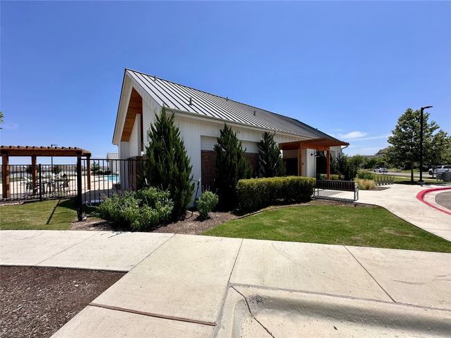 View of property exterior with a metal roof, a standing seam roof, and brick siding | Image 32