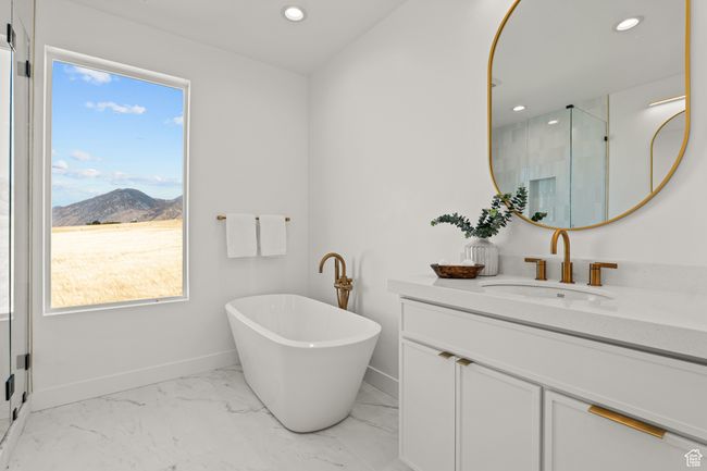 Full bathroom with a shower stall, vanity, light marble finish floors, a freestanding tub, and recessed lighting | Image 46