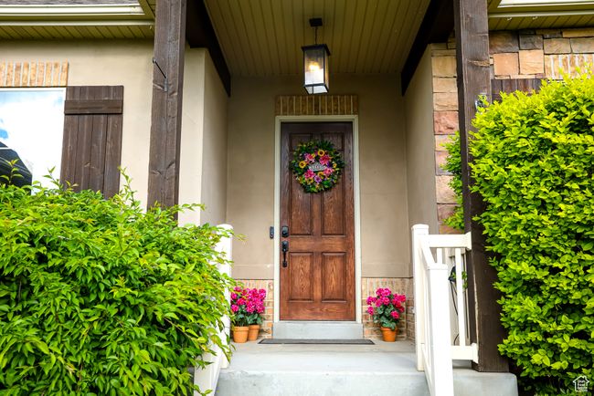 Doorway to property featuring stucco siding and a porch | Image 4