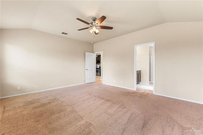 Unfurnished room featuring lofted ceiling, ceiling fan, and light colored carpet | Image 12