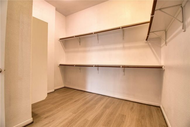 Spacious closet with light wood finished floors | Image 19