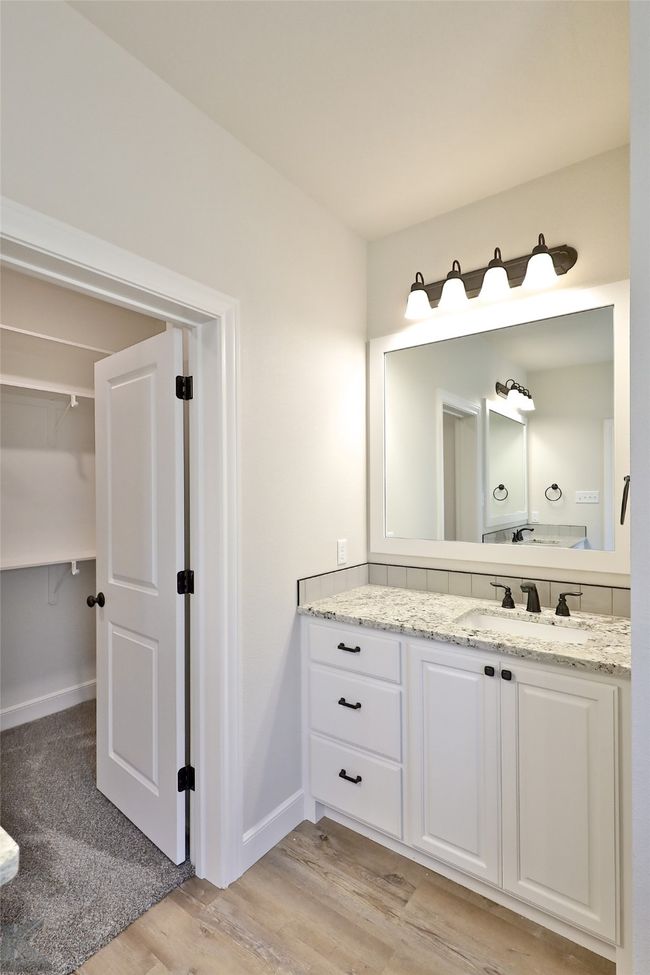 Bathroom with vanity, wood finished floors, and a walk in closet | Image 18