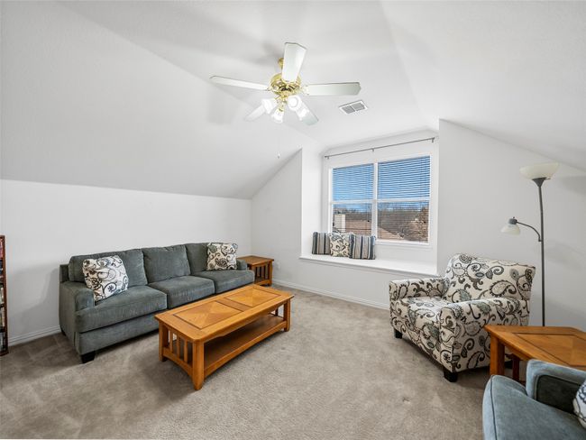 Living room with lofted ceiling, ceiling fan, visible vents, and carpet flooring | Image 26