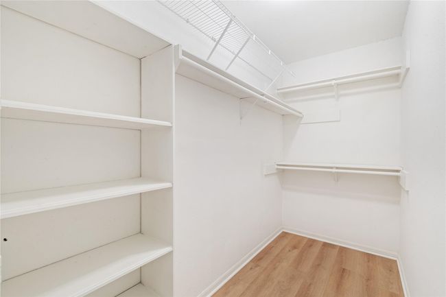 Walk-in closet with built-in shelving and hanging space for efficient storage. | Image 18