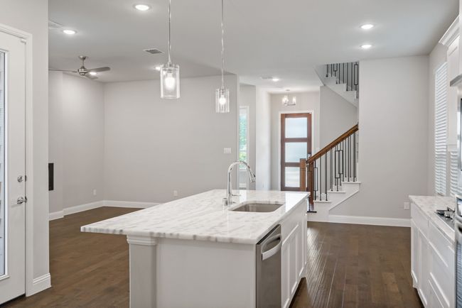 Kitchen featuring dark wood-type flooring, a sink, visible vents, dishwasher, and white cabinets | Image 12