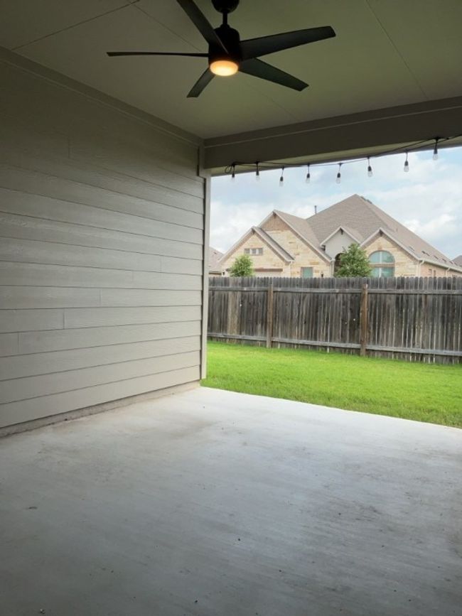 Fenced backyard with a patio and ceiling fan | Image 33