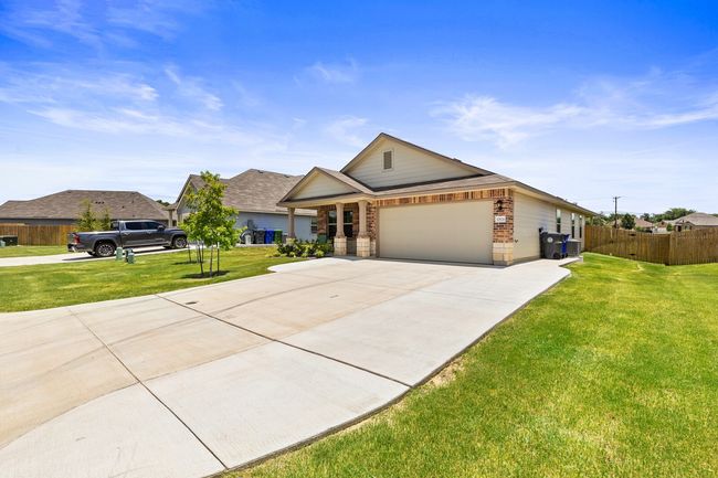 View of front of property featuring concrete driveway, a garage, and brick siding | Image 4