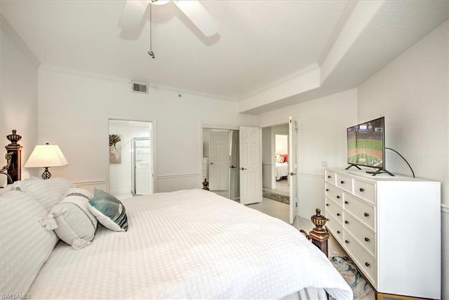 Bedroom featuring ensuite bathroom, a closet, visible vents, crown molding, and ceiling fan | Image 14