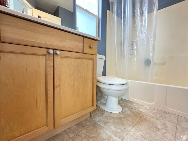 Full bathroom featuring tile flooring, vanity, toilet, and shower / tub combo | Image 10