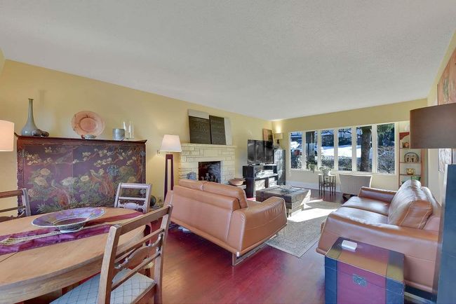 Living area featuring wood finished floors and a stone fireplace | Image 4