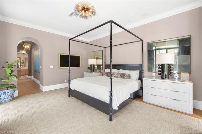 Bedroom with ornamental molding, light wood-type flooring, arched walkways, and baseboards | Image 22