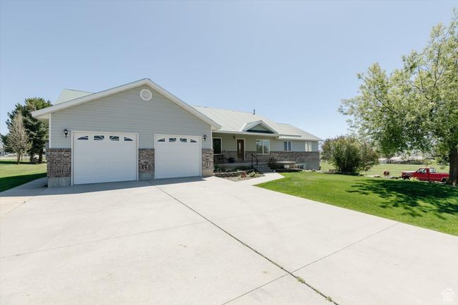Ranch-style house featuring a front yard, a garage, and concrete driveway | Image 13