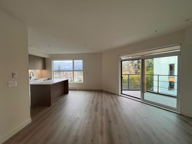 Unfurnished living room featuring light wood-style floors and a baseboard radiator | Image 11