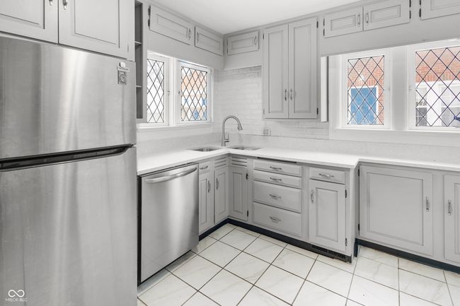 kitchen with light countertops, appliances with stainless steel finishes, gray cabinets, and a sink | Image 18