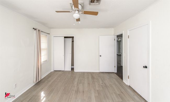 Unfurnished bedroom featuring baseboards, visible vents, crown molding, and light wood-style flooring | Image 8