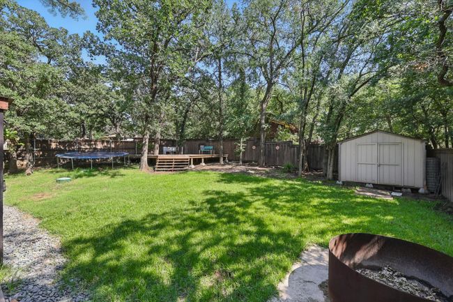 Fenced backyard with a trampoline and a storage unit | Image 31