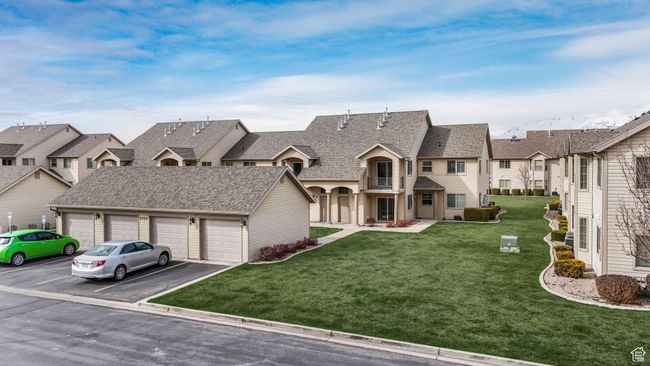View of front of home with community garages, a residential view, roof with shingles, and a front lawn | Image 19