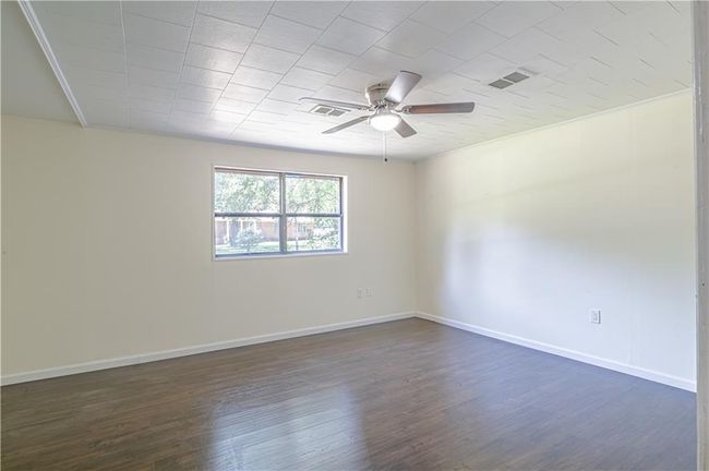Empty room featuring crown molding, ceiling fan, and dark hardwood / wood-style floors | Image 39