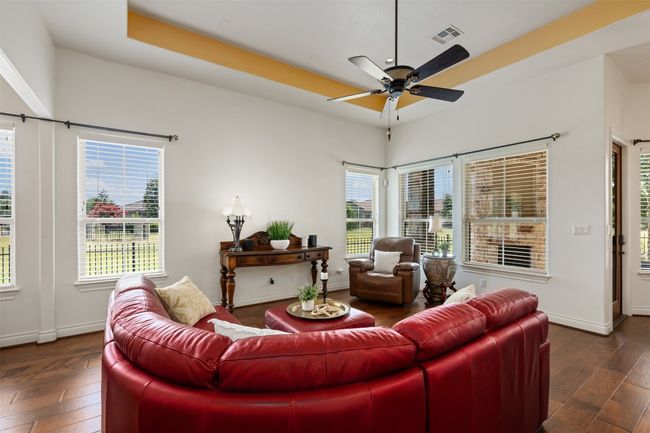 Living room with wood finished floors, ceiling fan, and healthy amount of natural light | Image 9