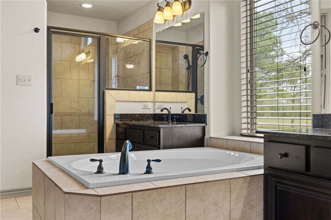 Full bathroom featuring a stall shower, tile patterned flooring, vanity, and a bath | Image 14
