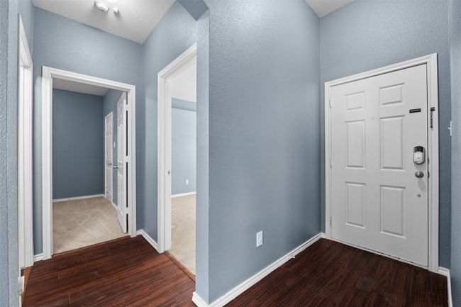 Foyer entrance with baseboards, a textured wall, and dark wood finished floors | Image 25