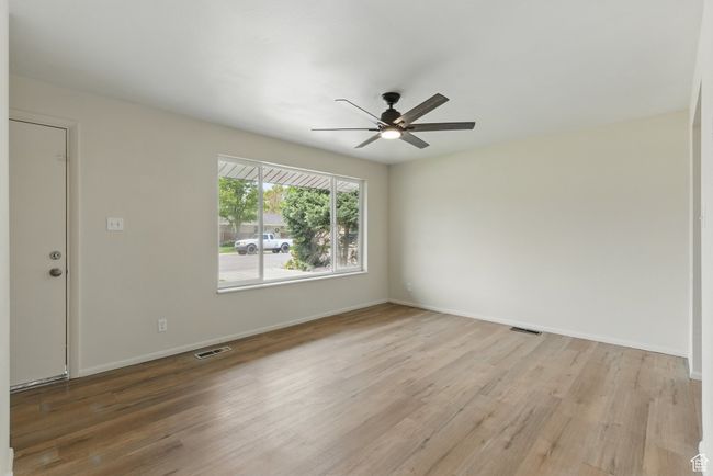 Empty room featuring wood finished floors, a ceiling fan, and baseboards | Image 4
