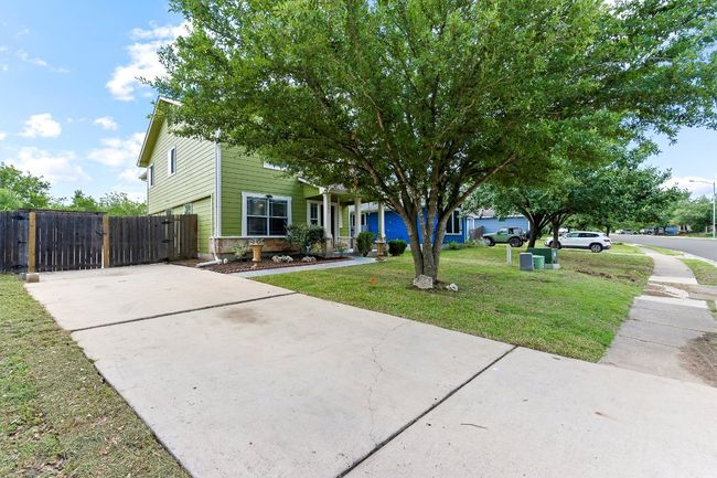 View of property hidden behind natural elements featuring driveway and a gate | Image 4