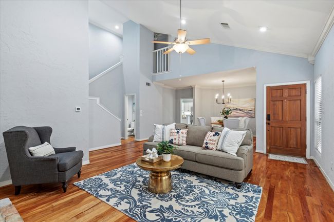 Living area featuring wood finished floors, ceiling fan, baseboards, ornamental molding, and high vaulted ceiling | Image 5
