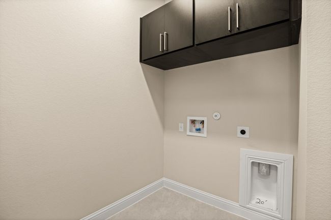 Clothes washing area featuring cabinet space, hookup for an electric dryer, hookup for a gas dryer, washer hookup, and baseboards | Image 12