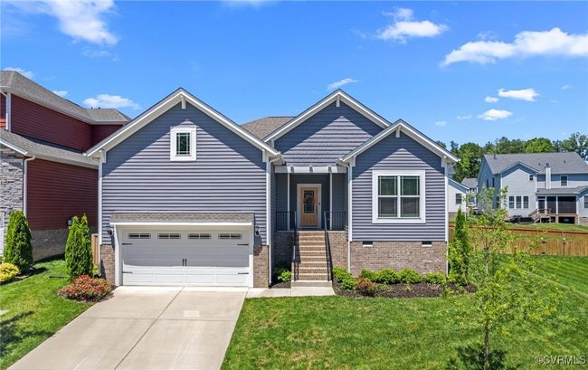 View of front of home with concrete driveway, a garage, and brick siding | Image 5