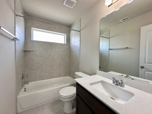 Full bathroom featuring bathing tub / shower combination, vanity, and tile patterned floors | Image 25