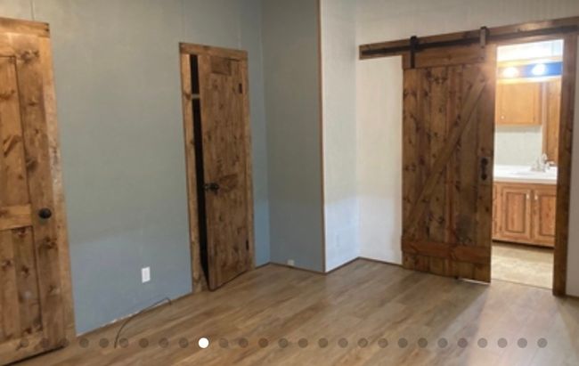 Unfurnished bedroom featuring light wood finished floors, a sink, and a barn door | Image 23