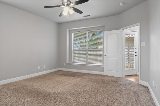 Empty room featuring light carpet, baseboards, ceiling fan, and a smoke detector | Image 29