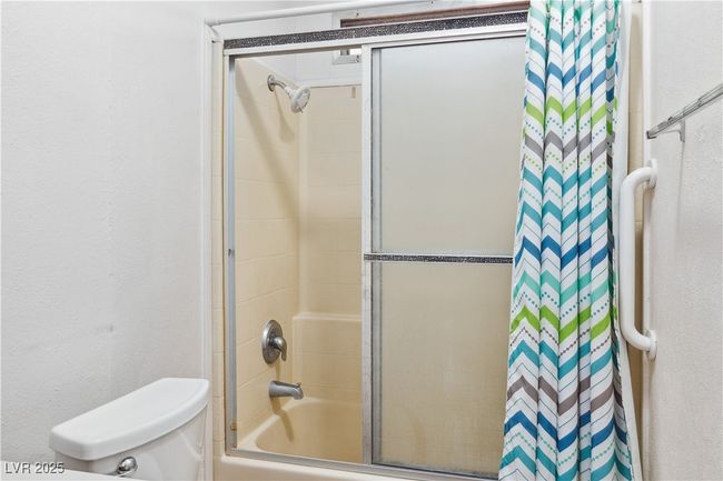 Bathroom featuring combined bath / shower with glass door and toilet | Image 19
