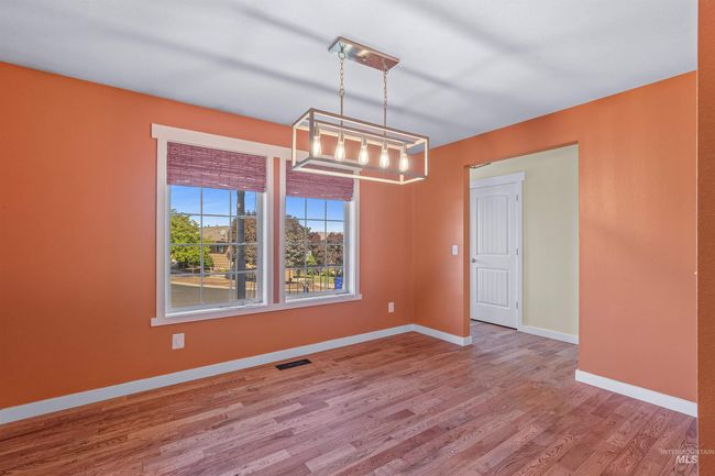 Empty room with wood finished floors and a chandelier | Image 15