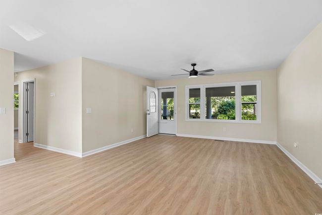 Unfurnished living room featuring light wood-style floors and a ceiling fan | Image 17