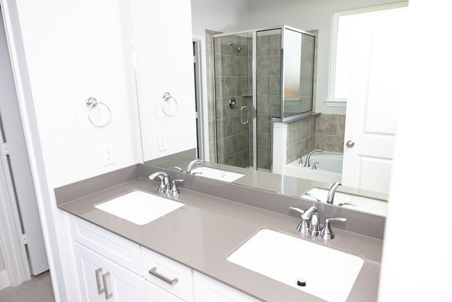 Bathroom featuring a stall shower, double vanity, a bath, and tile patterned flooring | Image 19
