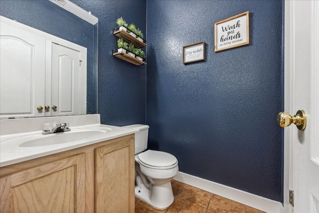 Half bathroom featuring a textured wall, vanity, tile patterned flooring, and baseboards | Image 15