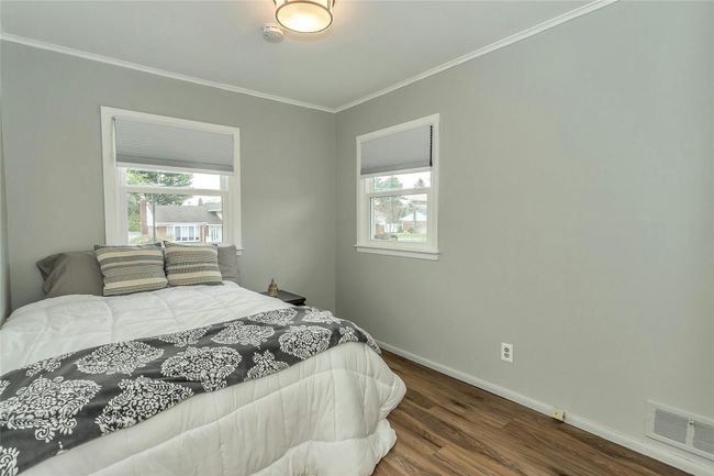 Bedroom featuring crown molding, visible vents, baseboards, and wood finished floors | Image 21