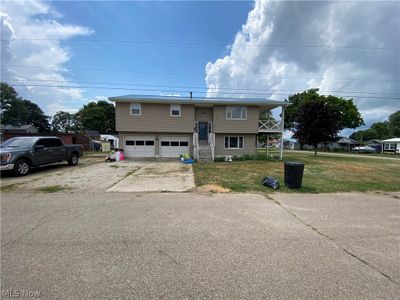 Bi-level home featuring a garage and a front yard | Image 1