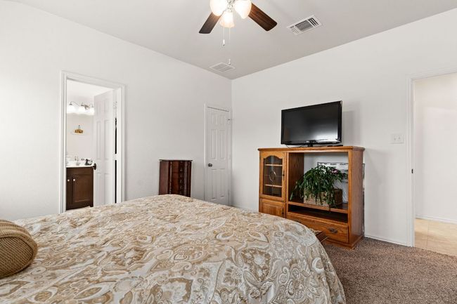 Bedroom featuring ensuite bath, visible vents, ceiling fan, and carpet | Image 13