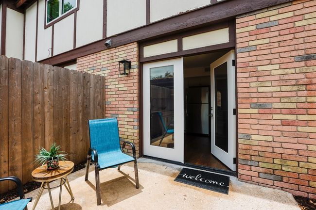 View of exterior entry featuring brick siding and a patio area. | Image 17