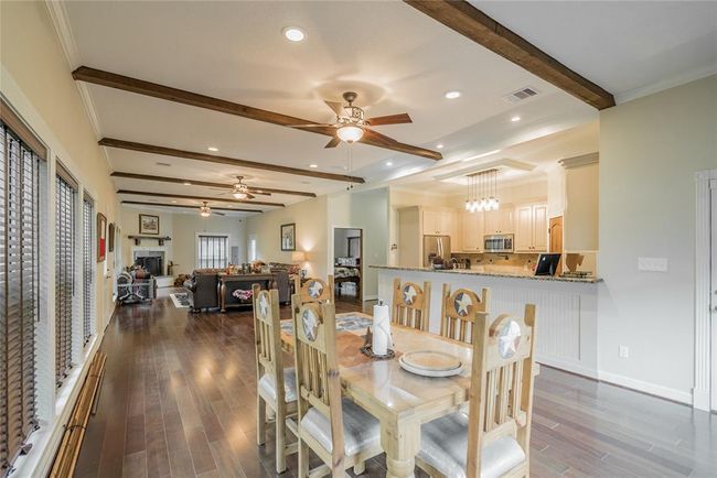 From this view, you can see this fabulous kitchen. It also is filled with light from the many windows and light fixtures in the home. There are STARS every while. Notice the Stars in the ceiling fans, on the furniture, doors, fireplace and other spots throughout the home. Notice the moldings on the ceiling and floors. | Image 19