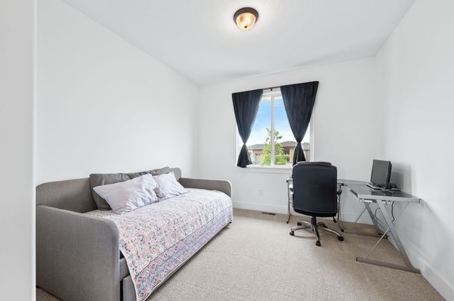 Bedroom with carpet floors, baseboards, and an office area | Image 20