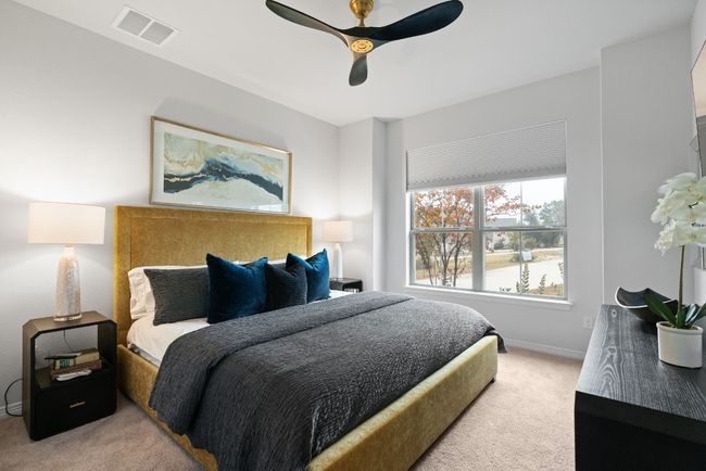 Another first floor bedroom featuring high ceilings, a ceiling fan, and carpet flooring. | Image 23